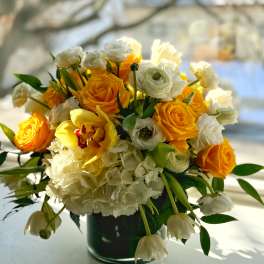 Yellow and white flower arrangement in a dark vase