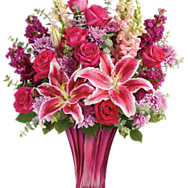 Pink roses and lilies in a tall glass vase