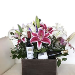 Flower arrangement in a wooden box with two wine bottles
