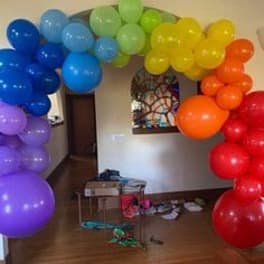Rainbow balloon arch framing a doorway in a room