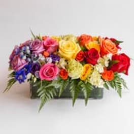 Colorful mixed rose arrangement in a rectangular container