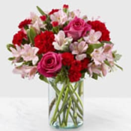 Pink and red mixed bouquet in a clear glass vase