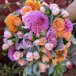 Bouquet of pink, lavender, and orange flowers with blue-gray foliage