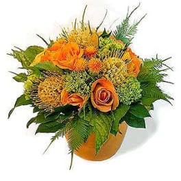 Orange roses and yellow-green flowers in a vase