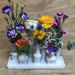 Mixed bouquet in white bud vases on a tray