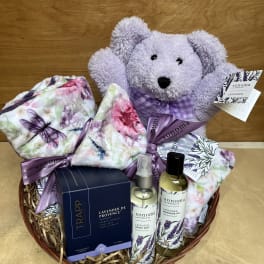 Lavender gift basket with a teddy bear, blankets, and bath products