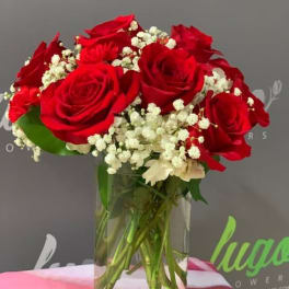Red roses and white baby's breath in a clear glass vase