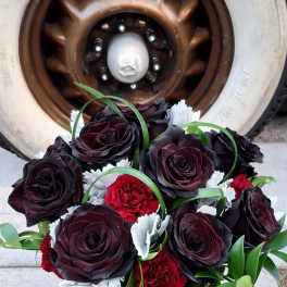 Bouquet of dark red roses and red carnations in a silver vase