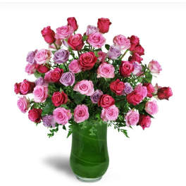 Pink and lavender roses in a green glass vase