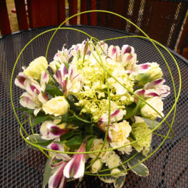 Bouquet of cream and purple flowers with green wire loops
