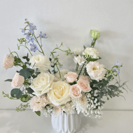 Pastel bouquet of roses and mixed blooms in a white vase