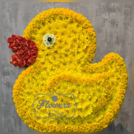 Duck-shaped floral arrangement made of yellow flowers with a red flower beak.