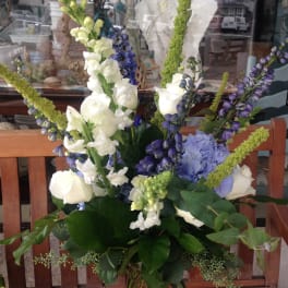 Tall bouquet of white and purple flowers in a glass vase