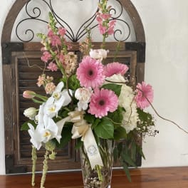 Pink and white mixed flower arrangement in a clear vase