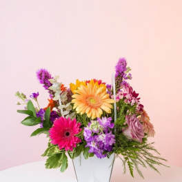 Colorful mixed flower arrangement in a white vase