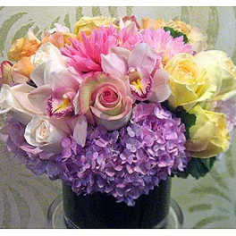 Mixed bouquet with roses, orchids, hydrangeas, and pink blooms in a vase