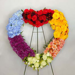 Rainbow heart-shaped floral wreath on a metal stand