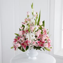Pink and white lilies and roses in a white vase
