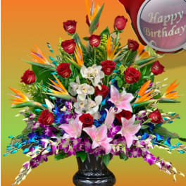 Large mixed bouquet with red roses, lilies, orchids, and bird-of-paradise in a black vase
