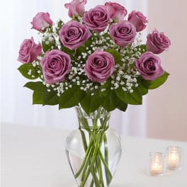 Pink roses arranged in a clear glass vase with baby's breath