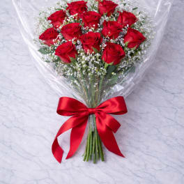 Bouquet of red roses wrapped in clear plastic with a red ribbon