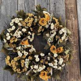 Autumn wreath with orange flowers and white berry clusters
