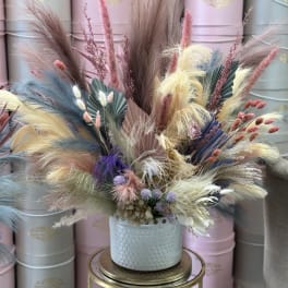 Pastel dried floral arrangement in a light blue vase