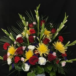 Red roses and yellow spider mums in a white vase
