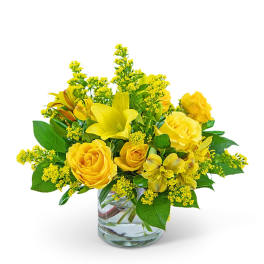 Yellow roses and lilies in a clear glass vase