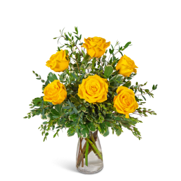 Yellow roses in a clear glass vase with mixed greenery
