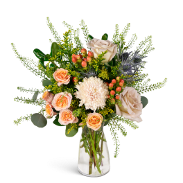 Bouquet of peach and cream flowers in a clear glass vase