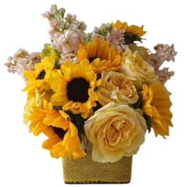 Sunflower and pale yellow rose arrangement in a square woven basket