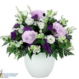 Lavender and white roses arranged in a white vase