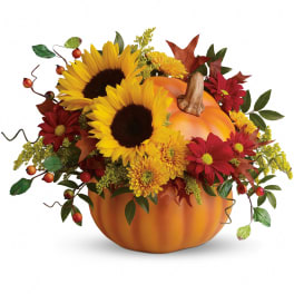 Fall bouquet arranged in a pumpkin container with sunflowers and mums