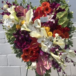 Heart-shaped floral standing arrangement with white calla lilies and orchids