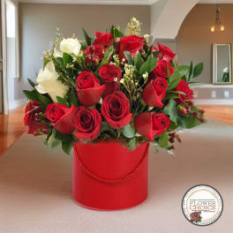 Red and white roses arranged in a red hatbox