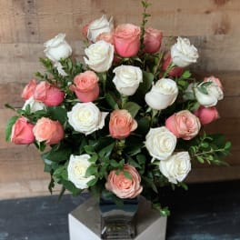 Bouquet of pink and white roses in a clear vase
