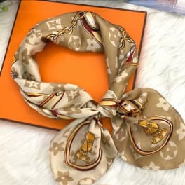 Patterned silk scarf tied in a knot on an orange box