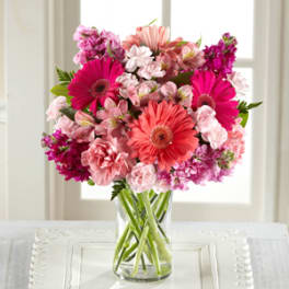 Pink and coral mixed bouquet in a clear glass vase