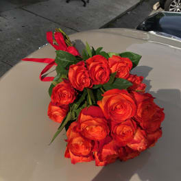 Bouquet of orange-red roses tied with a red ribbon