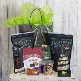 Gift bag filled with snack bags, candy, and a jar of mixed nuts