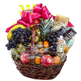 Gift basket with fruit, chocolates, and a pink ribbon bow