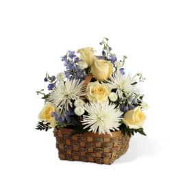 Basket arrangement with yellow roses, white spider mums, and blue flowers