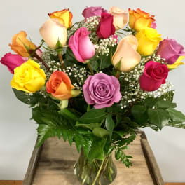 Mixed-color roses in a clear glass vase with baby's breath