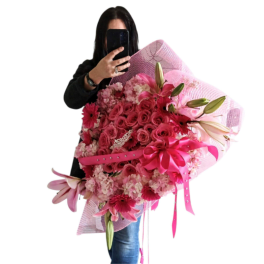 Large pink bouquet with roses, lilies, and gerbera daisies wrapped in pink mesh