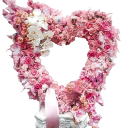Heart-shaped pink floral arrangement with roses and orchids on a pedestal