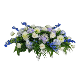 Low floral arrangement of white and blue flowers with palm fronds