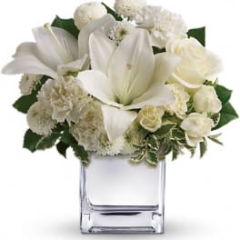 White floral arrangement in a clear square vase