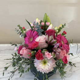 Pink and white mixed bouquet in a dark glass vase