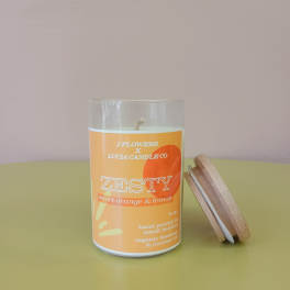 Orange scented candle in a glass jar with a wooden lid